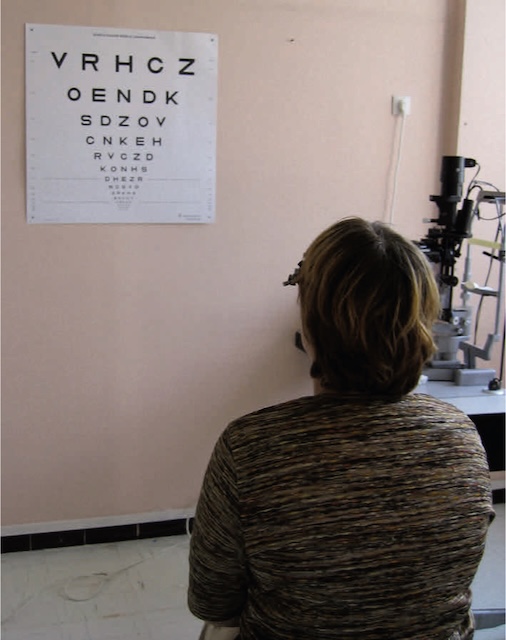 Photographie d’un test d’acuité visuelle à distance, réalisé avec un tableau optométrique dans un cabinet d’ophtalmologie.